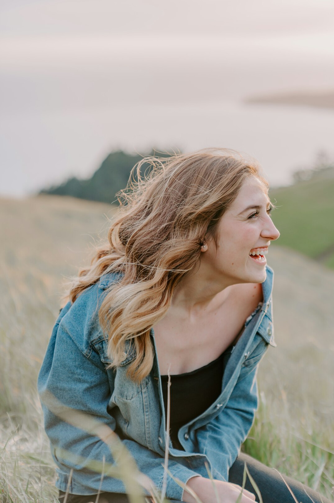 Portrait of a woman with wavy hair smiling outdoors