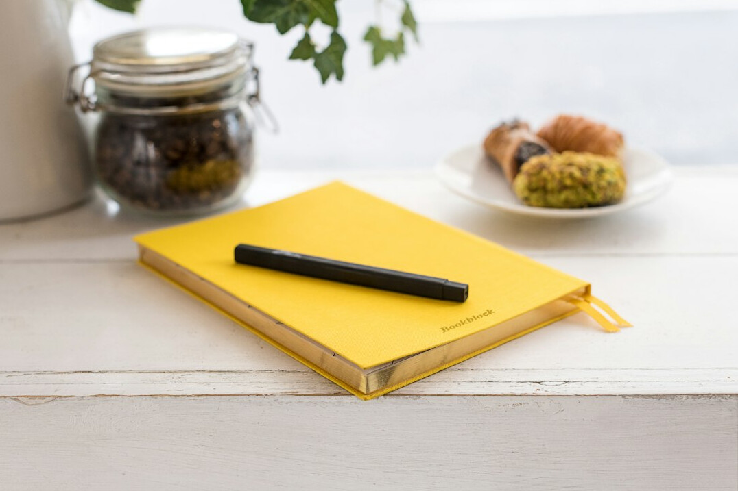 Pen writing in a notebook on a wooden desk